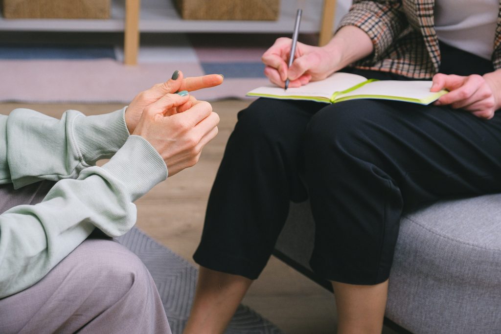 Student taking notes during somatic breathwork training, learning trauma-informed theory and nervous system foundations.