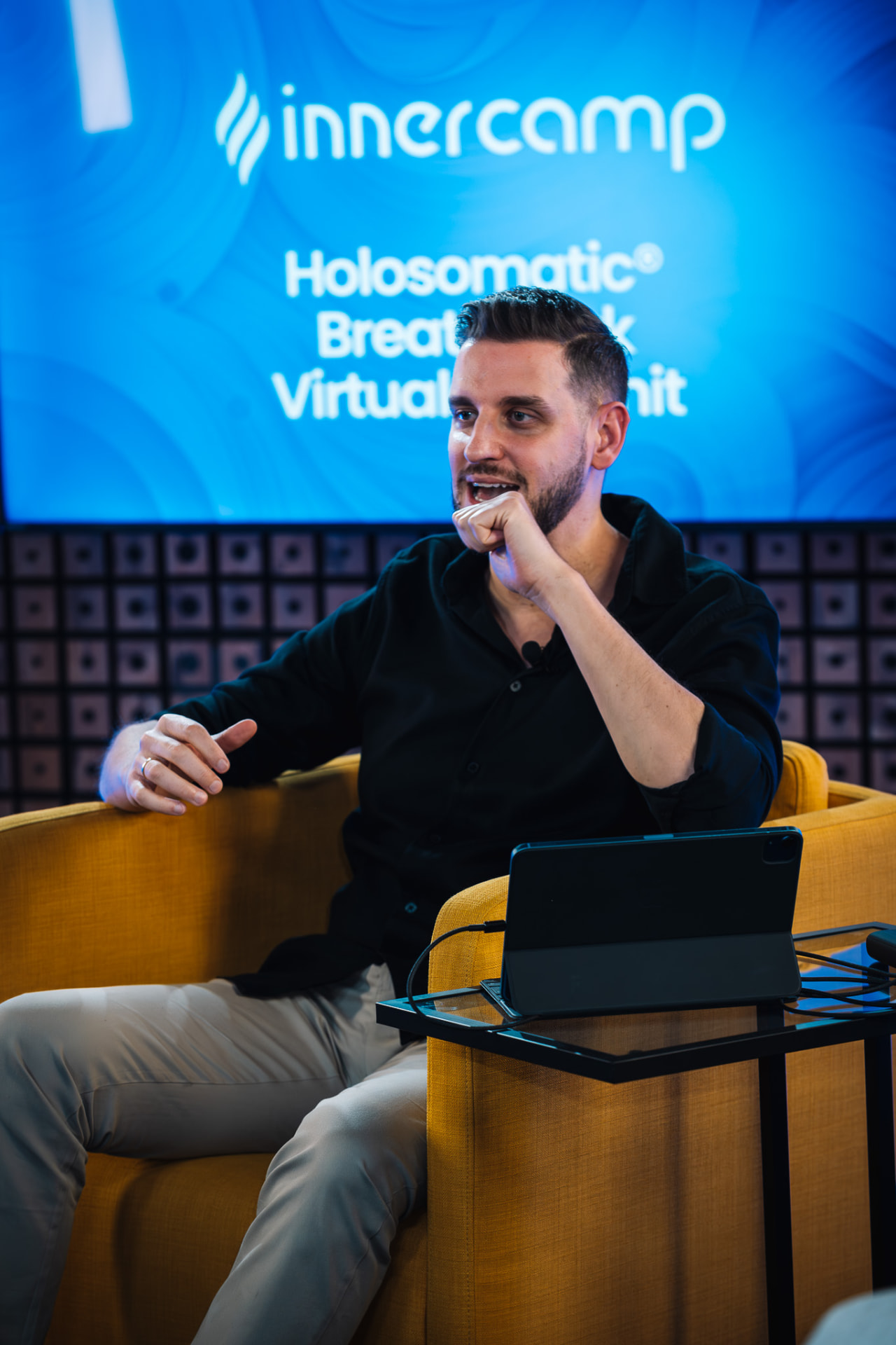 Alexis Alcalá speaking from the studio armchair during the Holosomatic® Breathwork Virtual Summit