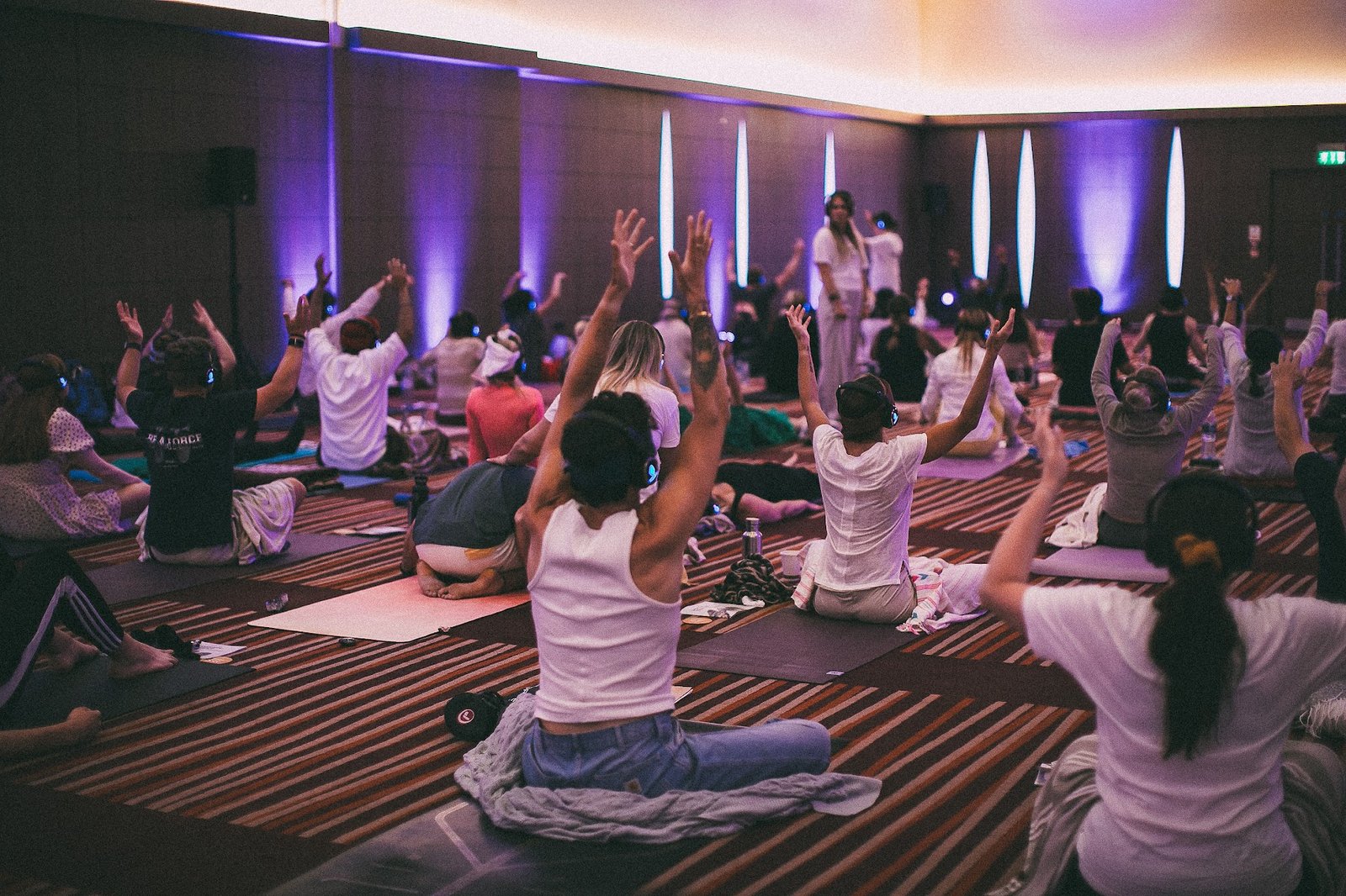 Hundreds of people with arms raised during a breathwork session