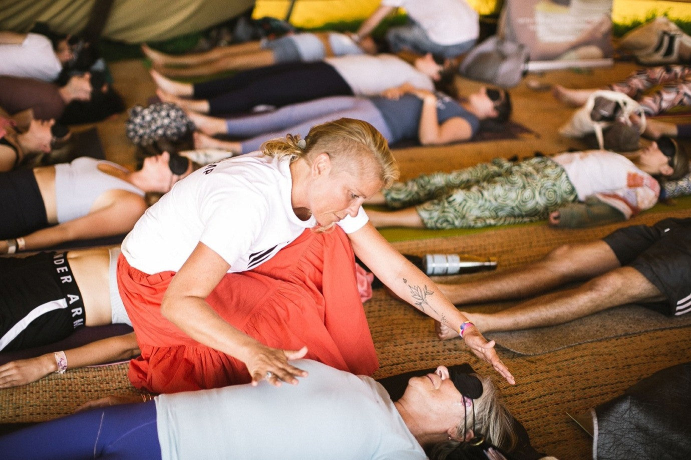 Group breathwork instructor training with facilitator offering safe support during a guided session