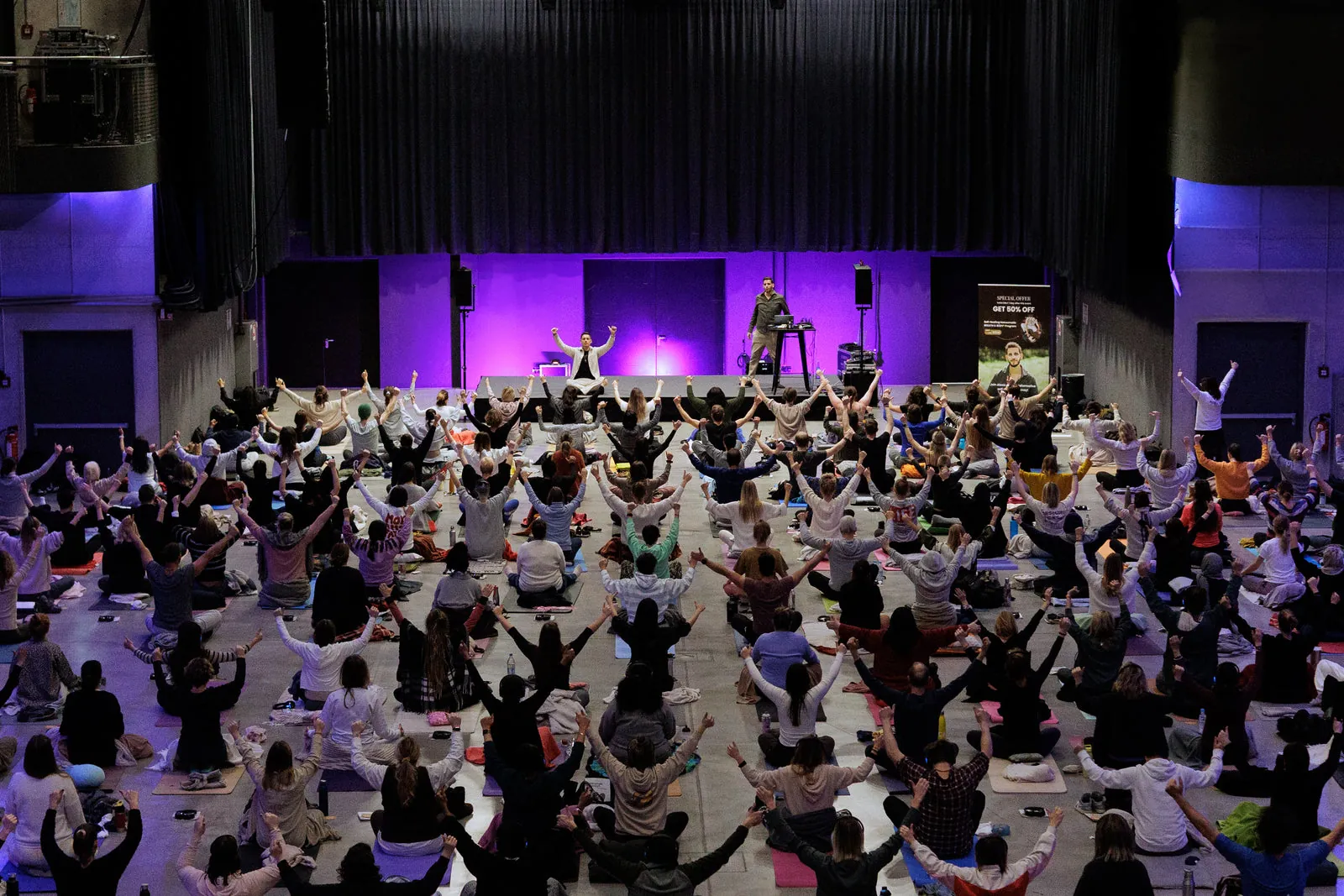 Hundreds of people practising breathwork together at an InnerCamp event